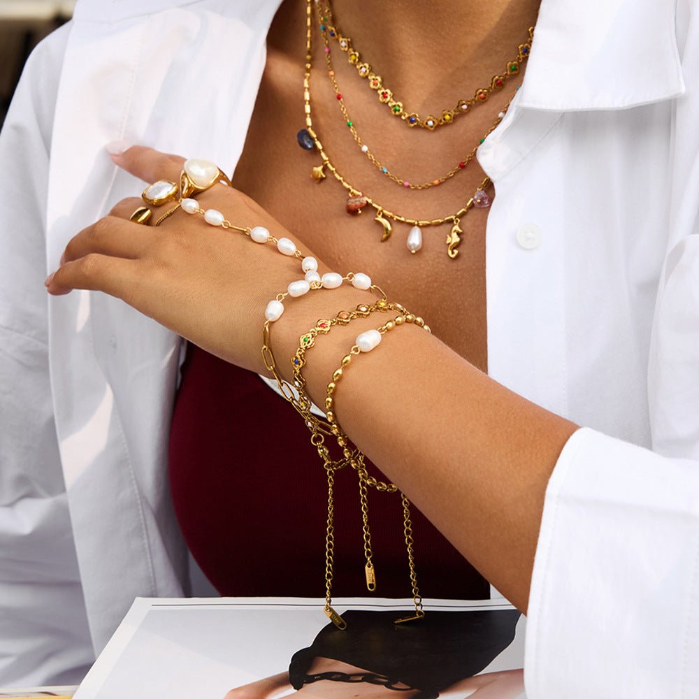 Bijou de main raffiné en acier inoxydable, chaîne dorée et perles blanches, bracelet fantaisie chic et moderne, modèle Urima — photo 2