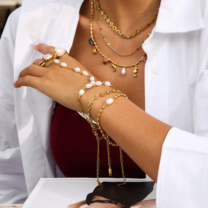Bijou de main raffiné en acier inoxydable, chaîne dorée et perles blanches, bracelet fantaisie chic et moderne, modèle Urima — photo 2