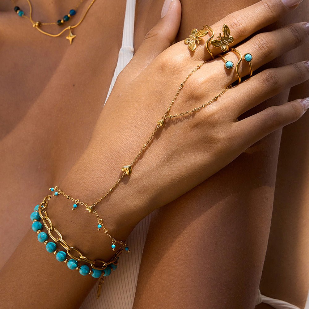 Bijou de main pour femme, acier inoxydable doré à perles turquoise et chaînette cœur, modèle Cigara — photo 3