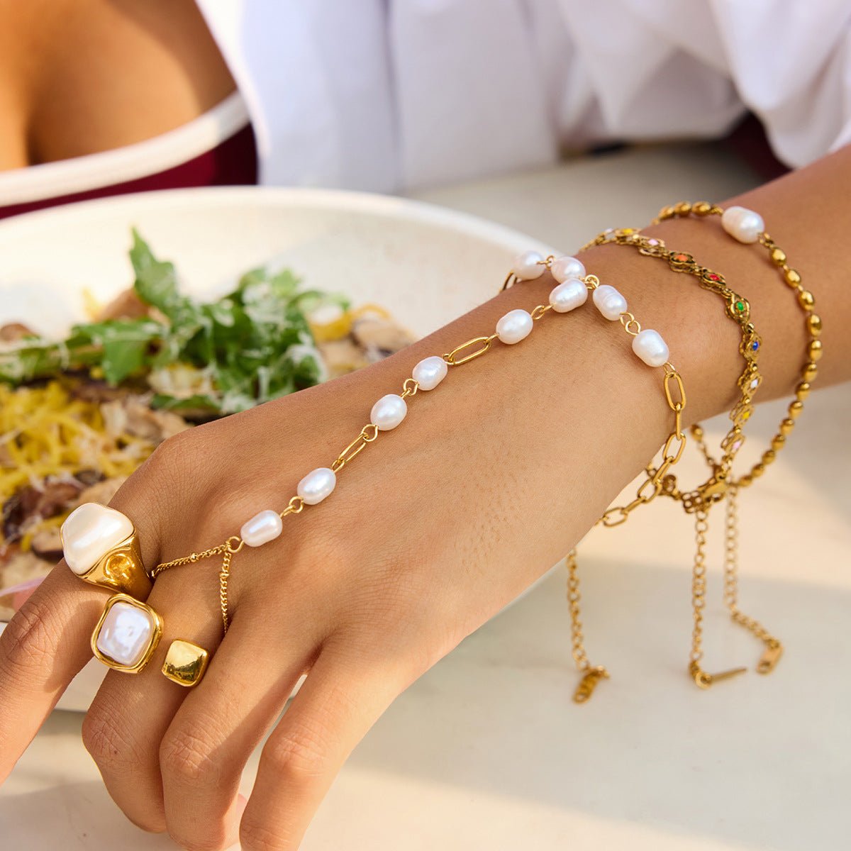 Bijou de main raffiné en acier inoxydable, chaîne dorée et perles blanches, bracelet fantaisie chic et moderne, modèle Urima — photo 3