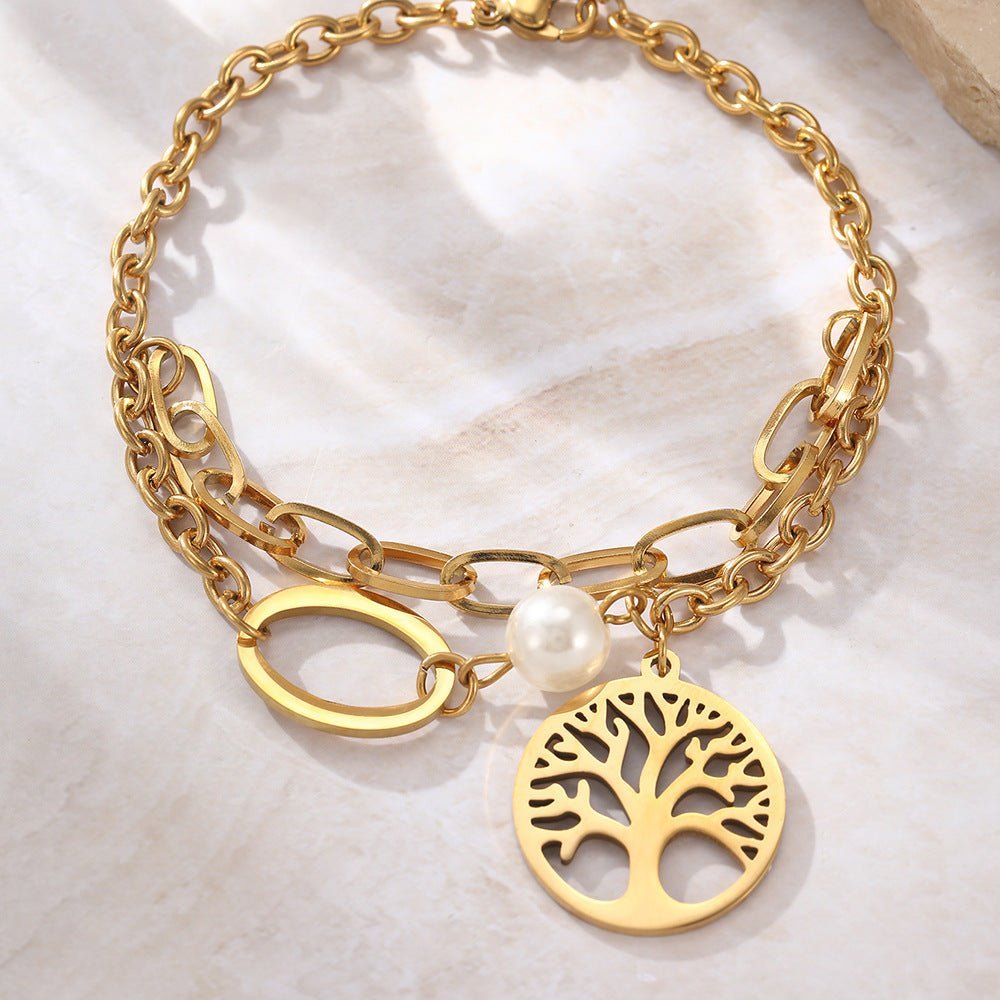 Bracelet double en acier inoxydable doré avec pendentif arbre de vie et perle blanche.