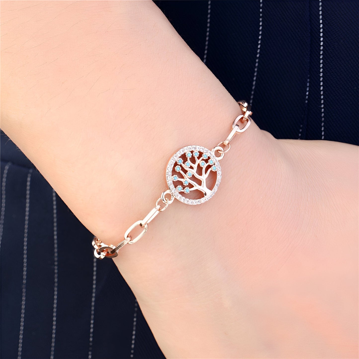 Bracelet en acier inoxydable or rosé avec pendentif arbre de vie rond et chaîne à maillons élégante.