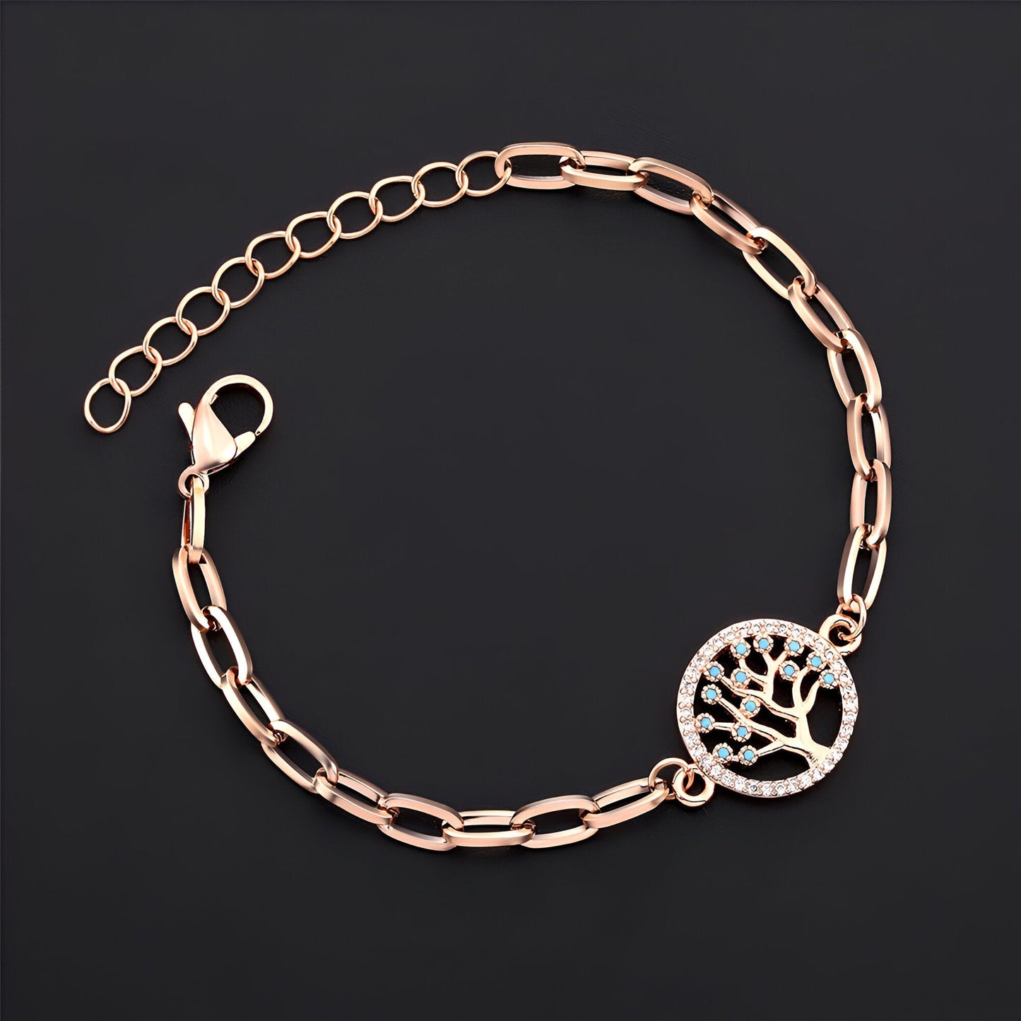 Bracelet or rosé en acier inoxydable avec pendentif arbre de vie orné de petites pierres brillantes.