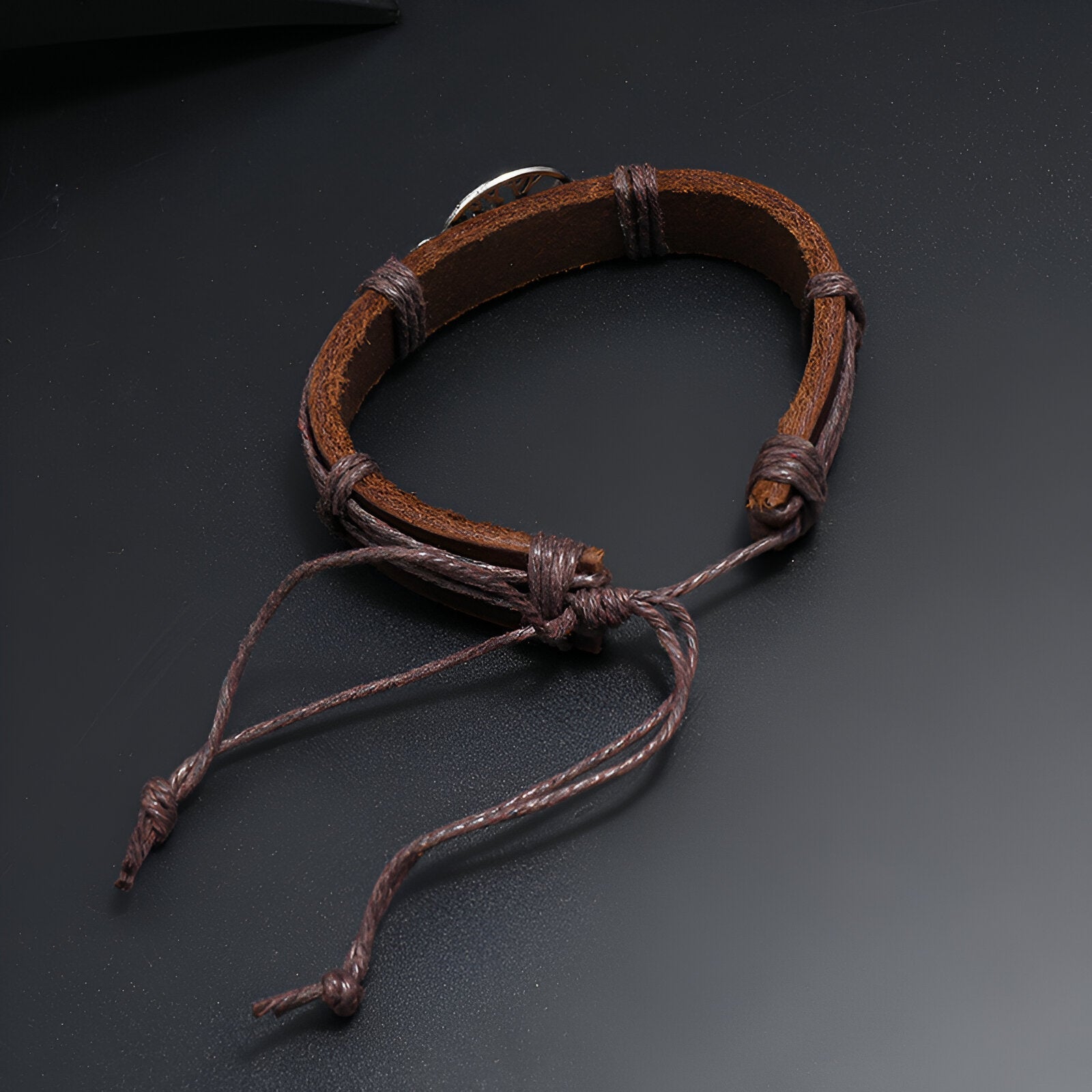 Bracelet en cuir marron avec pendentif arbre de vie et cordons ajustables en nœud coulissant.