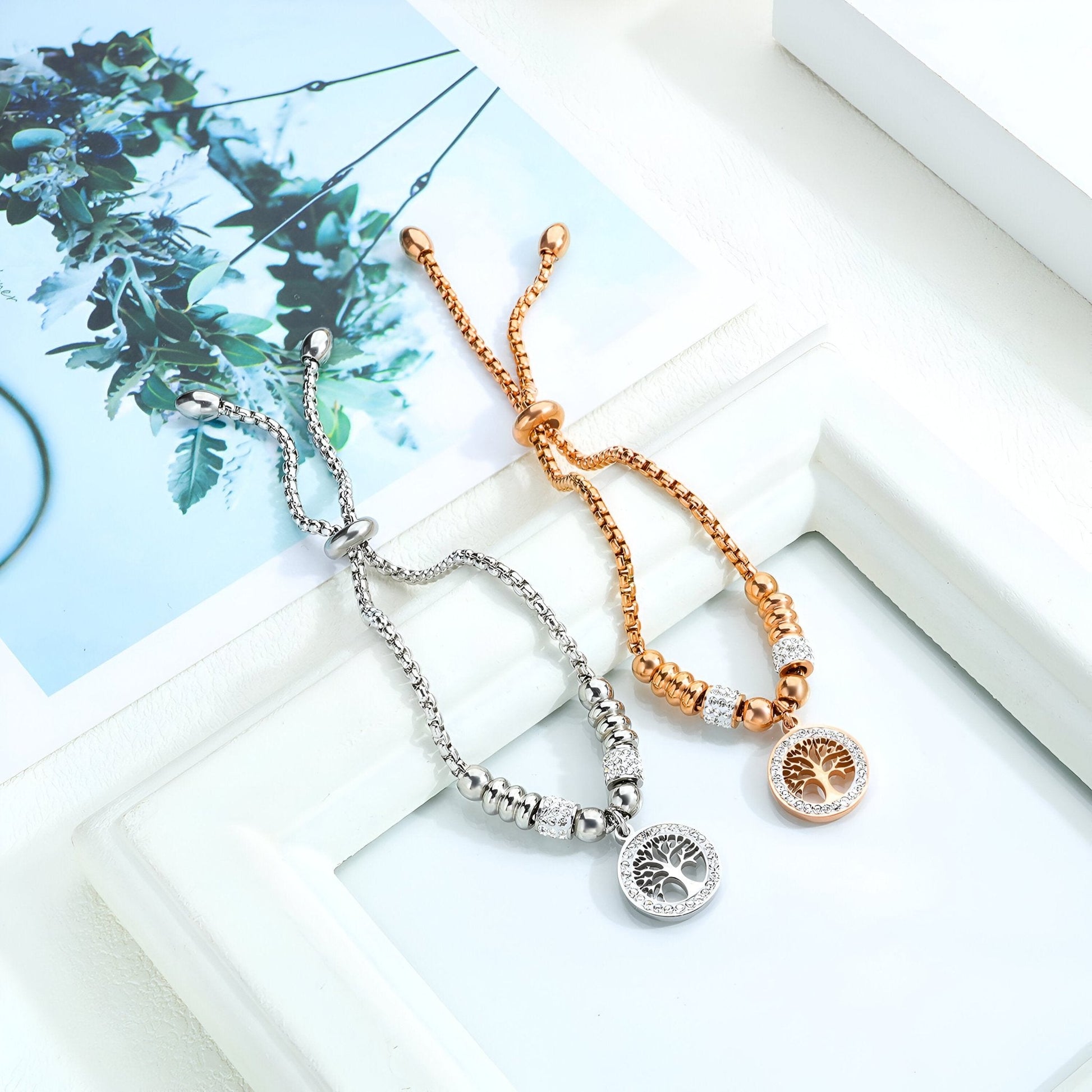 Bracelet en maille réglable en or rosé avec pendentif arbre de vie en zircon synthétique et bracelet similaire en argent.