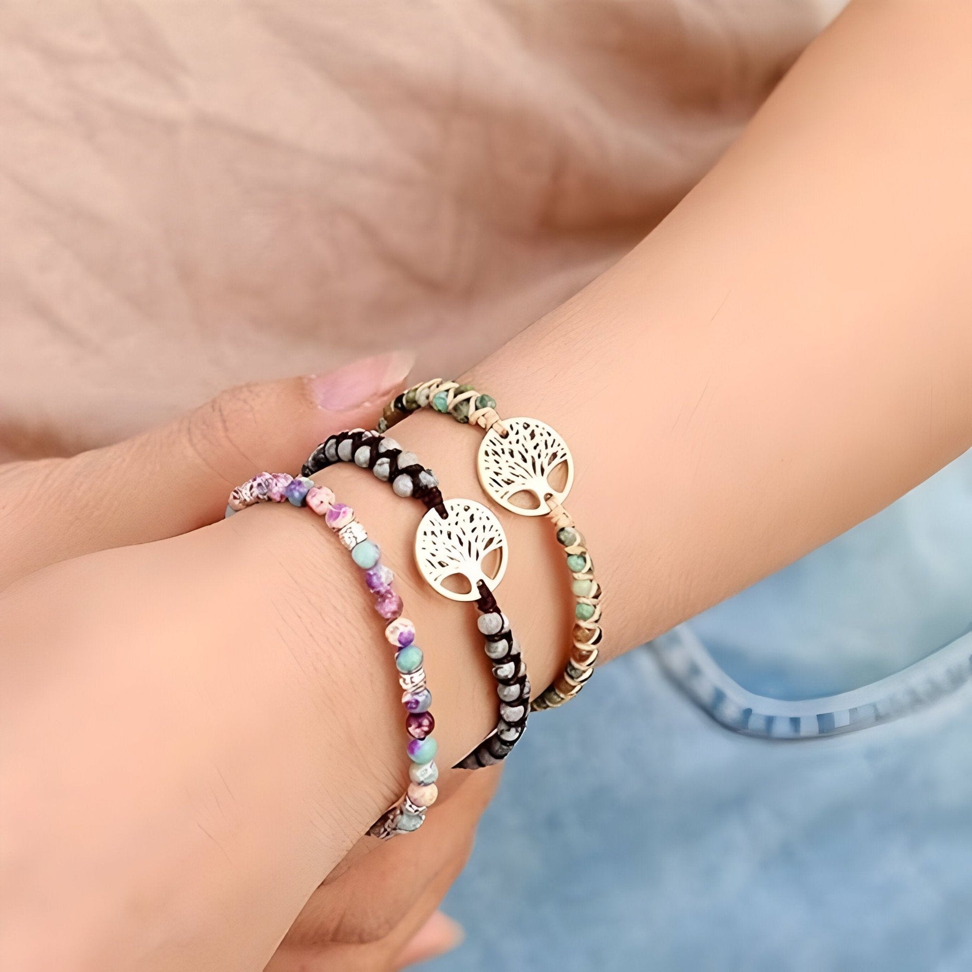 Trio de bracelets femme multi-rangs en pierres naturelles beige, marron et pastels avec pendentifs arbre de vie dorés.